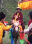  仁波切戴著前世的帽子，正式服裝騎馬抵達紅山寺廟